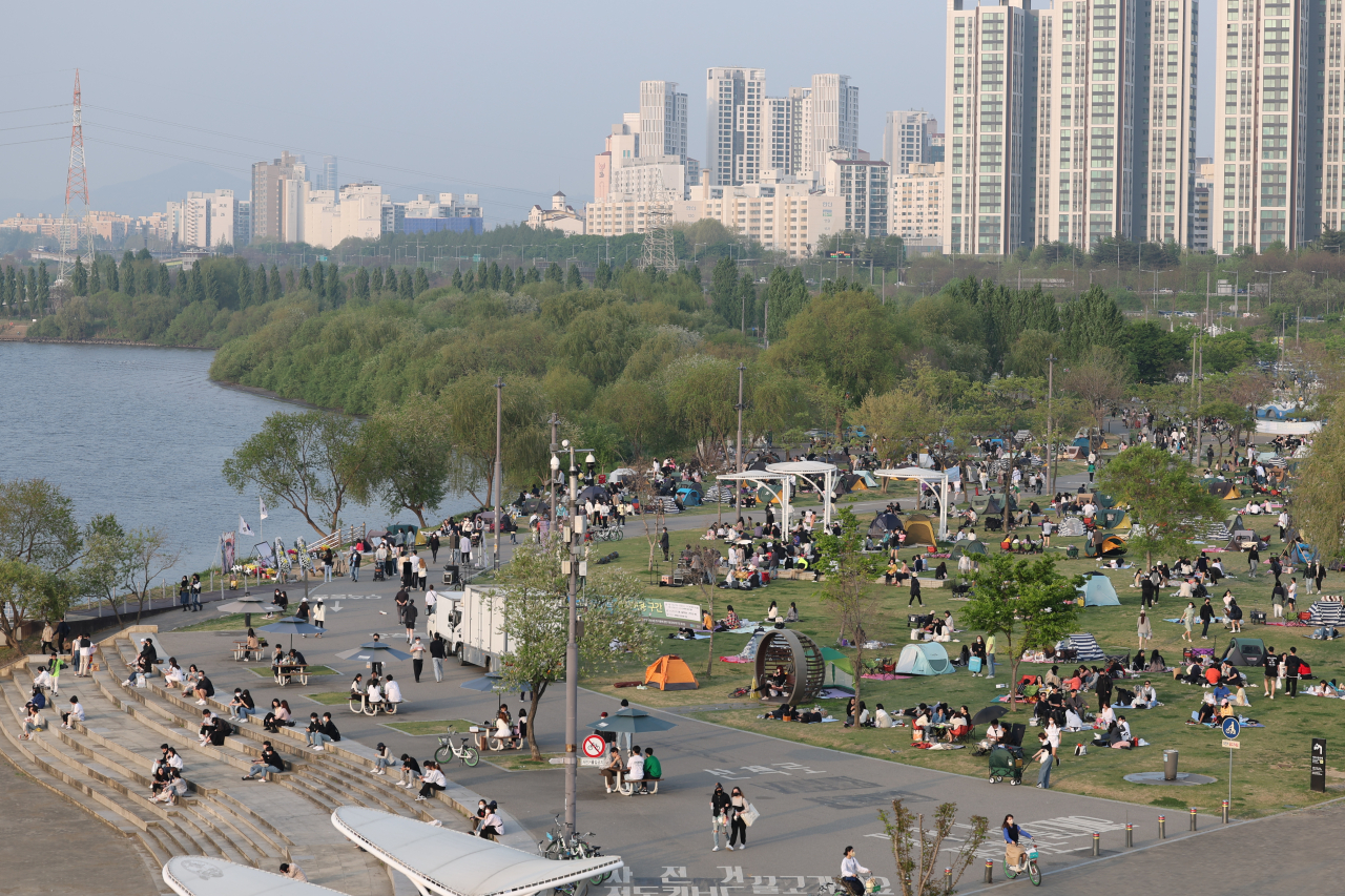 Picnickers crowd the riverside park in Seoul’s southwestern Banpo on Sunday. South Korea ended all social distancing restrictions on April 18. (Yonhap)