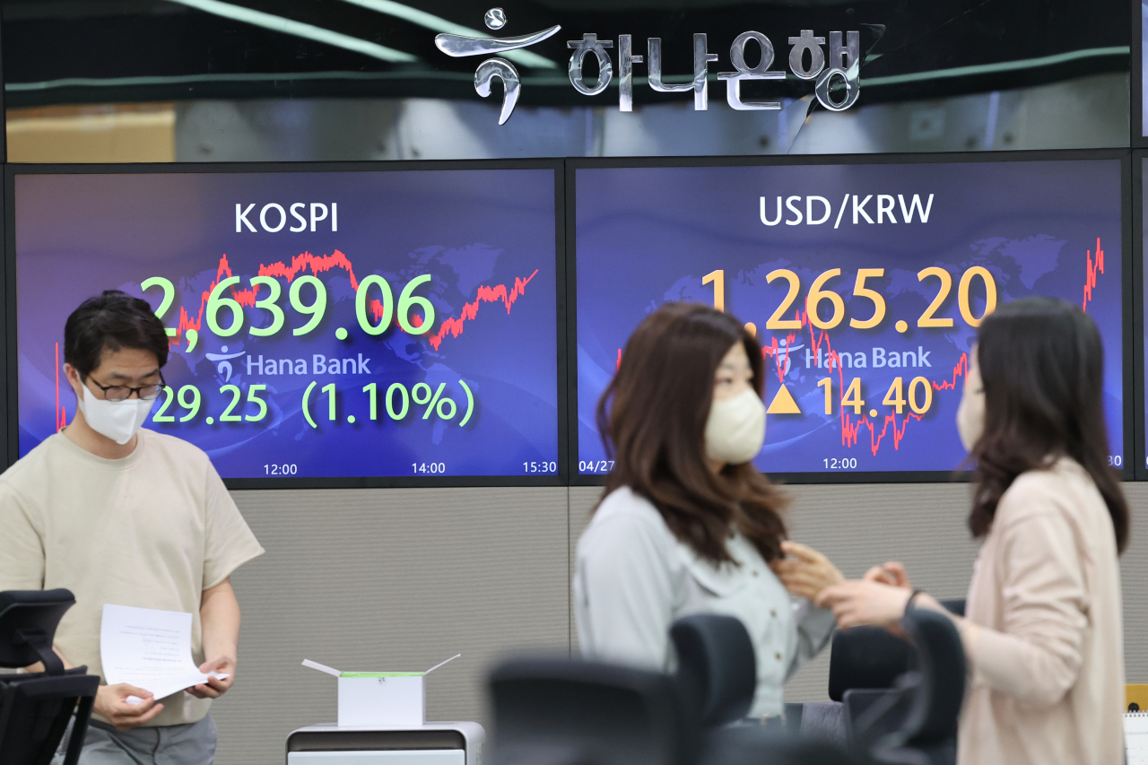 The photo shows information about the KOSPI (L), South Korea's main stock index, and the won on screens at a Hana Bank branch in central Seoul on Wednesday. (Yonhap)