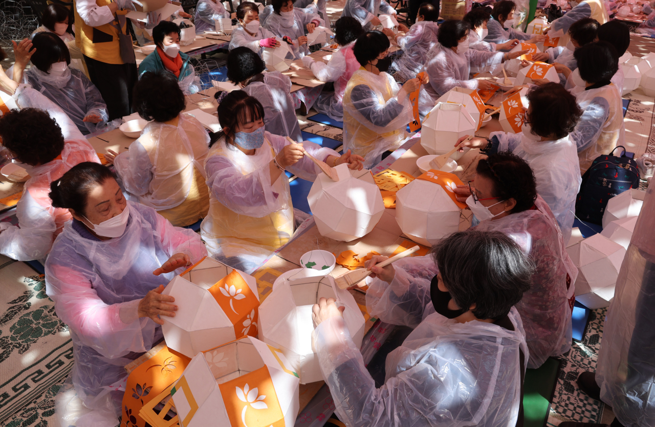 People make lotus lanterns for Yeondeunghoe on Wednesday at Jogyesa. (Yonhap)