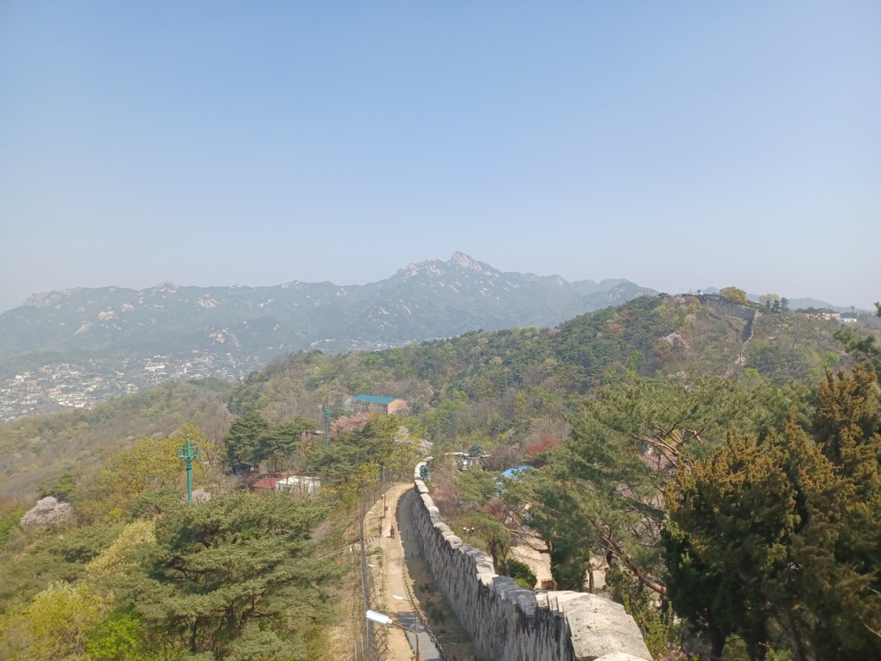 A panoramic view from the Cheongundae Peak includes a stone fortress wall and peaks of Bukhansan on April 21. (Lee Si-jin/The Korea Herald)