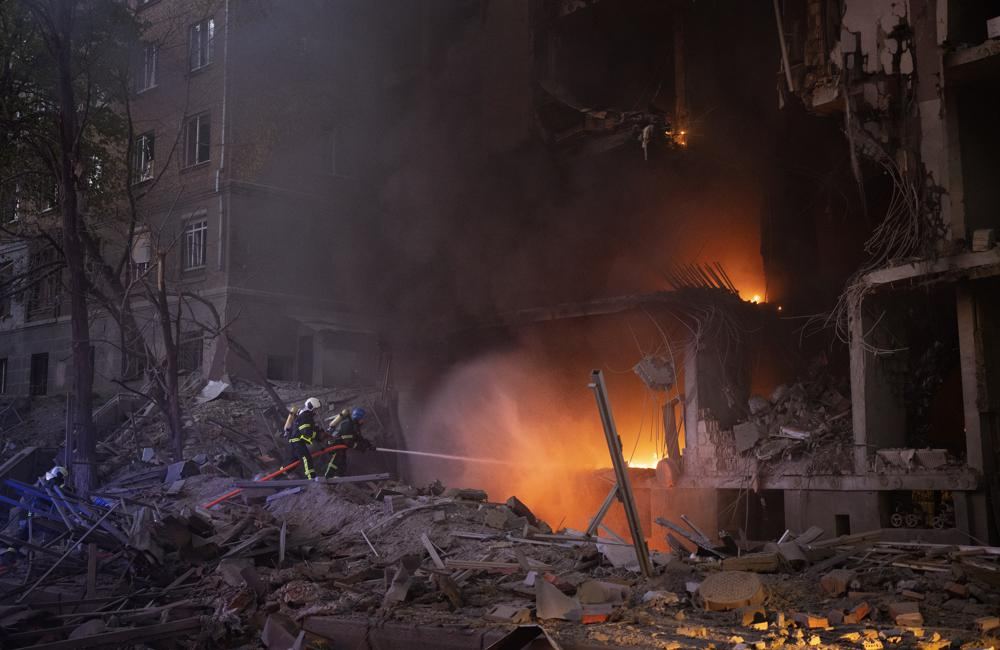 Firefighters try to put out a fire following an explosion in Kyiv, Ukraine on Thursday. Russia mounted attacks across a wide area of Ukraine on Thursday, bombarding Kyiv during a visit by the head of the United Nations. (AP)