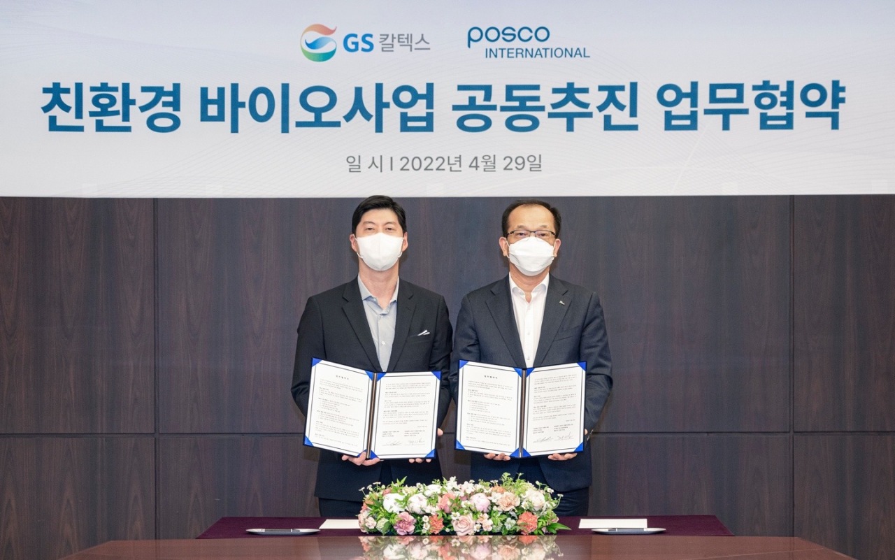 GS Caltex CEO Hur Sae-hong (left) and Posco International CEO Ju Si-bo pose after signing a partnership deal at GS Tower in Seoul, Friday. (GS Caltex)