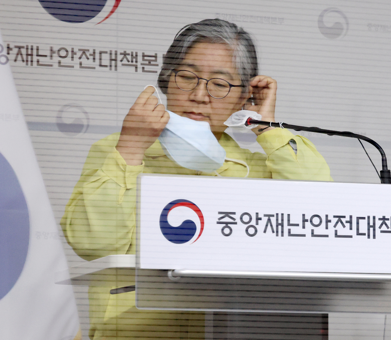 Korea Disease Control and Prevention Agency commissioner Jeong Eun-kyeong takes off her mask during a briefing at the Sejong government complex Friday. (Yonhap)