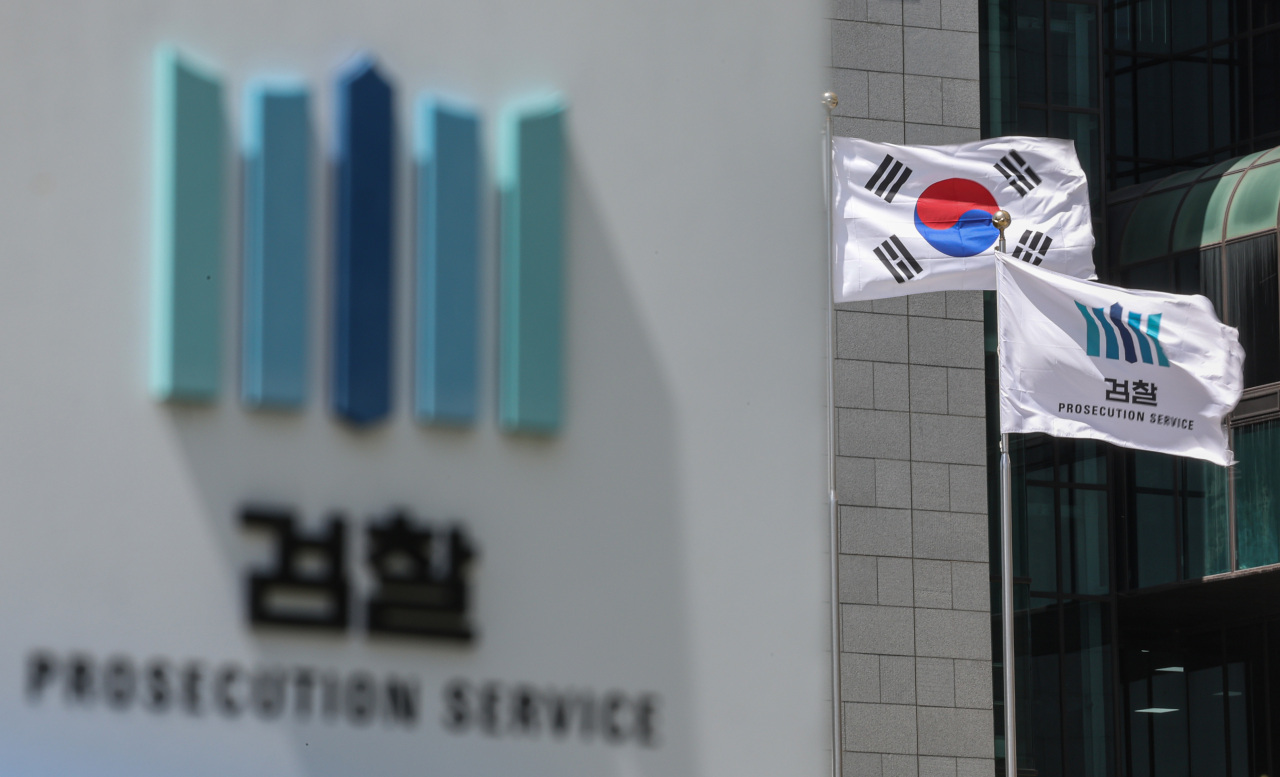 Flags flutter in the wind outside the prosecution service building on Sunday. (Yonhap)