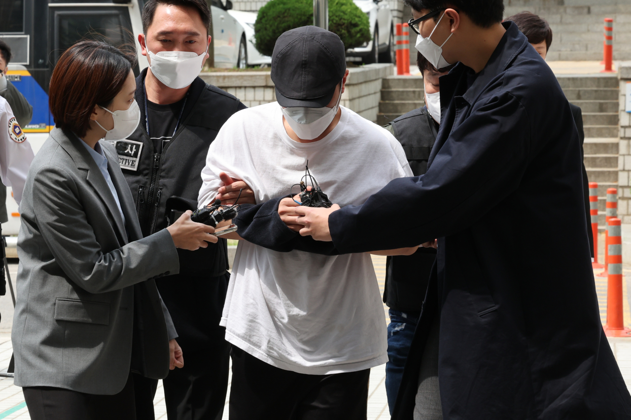 A Woori Bank employee under police investigation for allegedly embezzling more than 60 billion won arrives at the Seoul Central District Court for a hearing on April 30. (Yonhap)