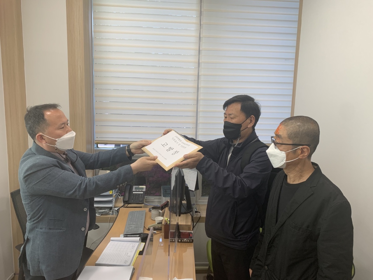 Civic group leader Oh Dong-chul and mime artist Yu Jin-kyu file a complaint against the head of the Cultural Heritage Administration at the Chuncheon police station, on Monday. (Pan-citizens' Countermeasure Committee)