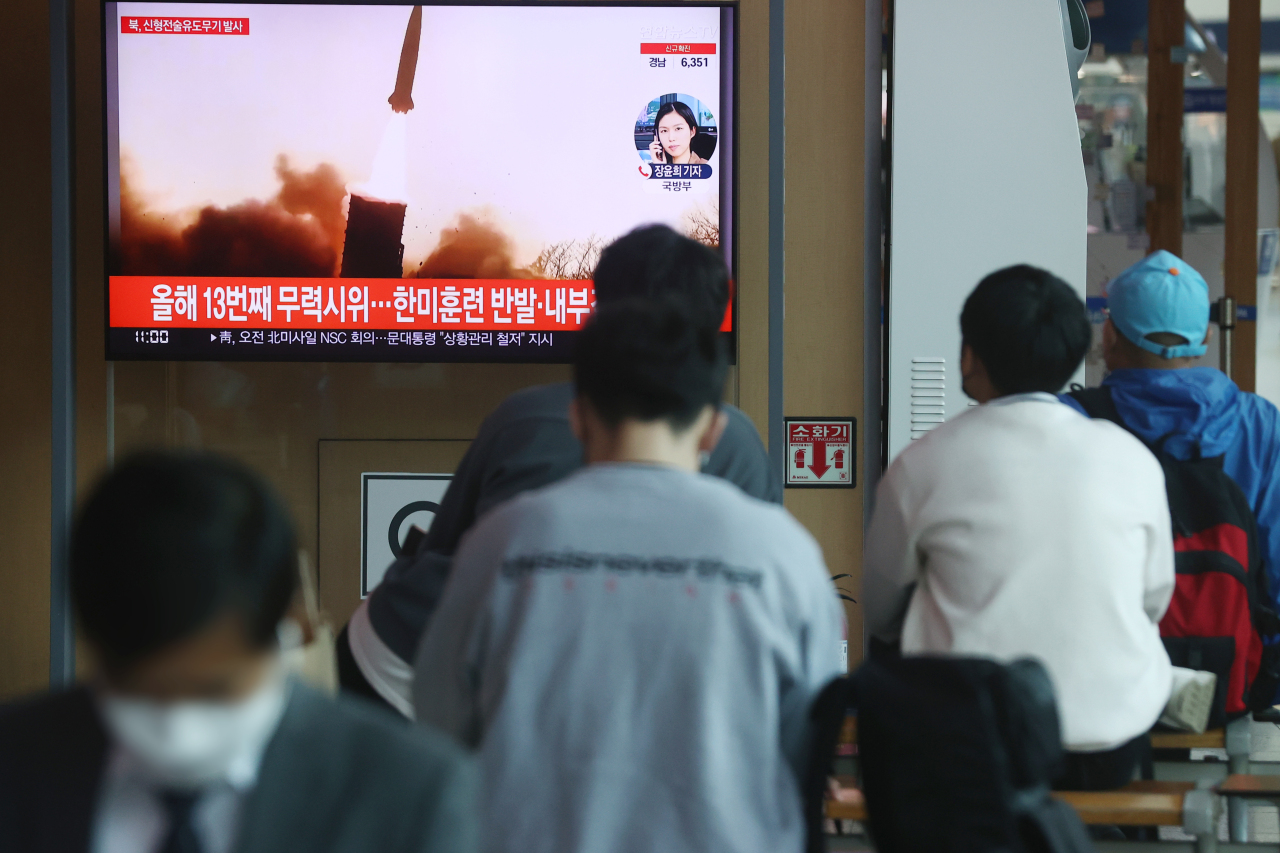 Passersby watch a TV report of North Korea’s missile launch at Seoul Station. (File Photo - Yonhap)