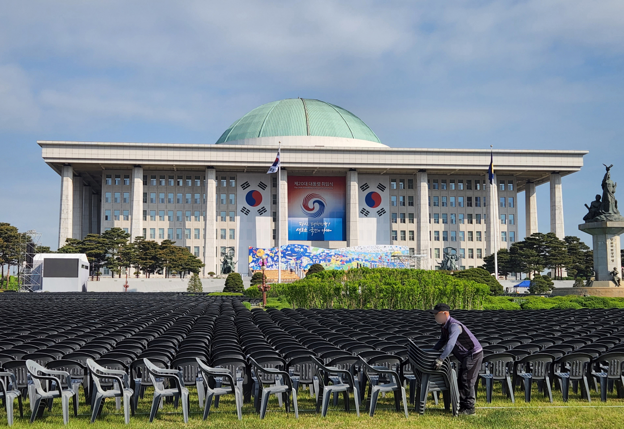 A worker installs chairs at the National Assembly plaza in Seoul on Friday, as part of preparations for the May 10 inauguration ceremony of incoming President Yoon Suk-yeol. (Yonhap)