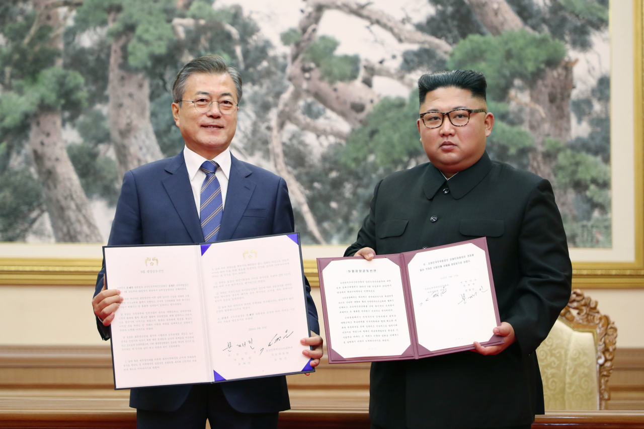 President Moon Jae-in (left) and leader Kim Jong-un hold the Pyongyang Joint Declaration at the third inter-Korean summit in September 2018. (Joint Press Corps)