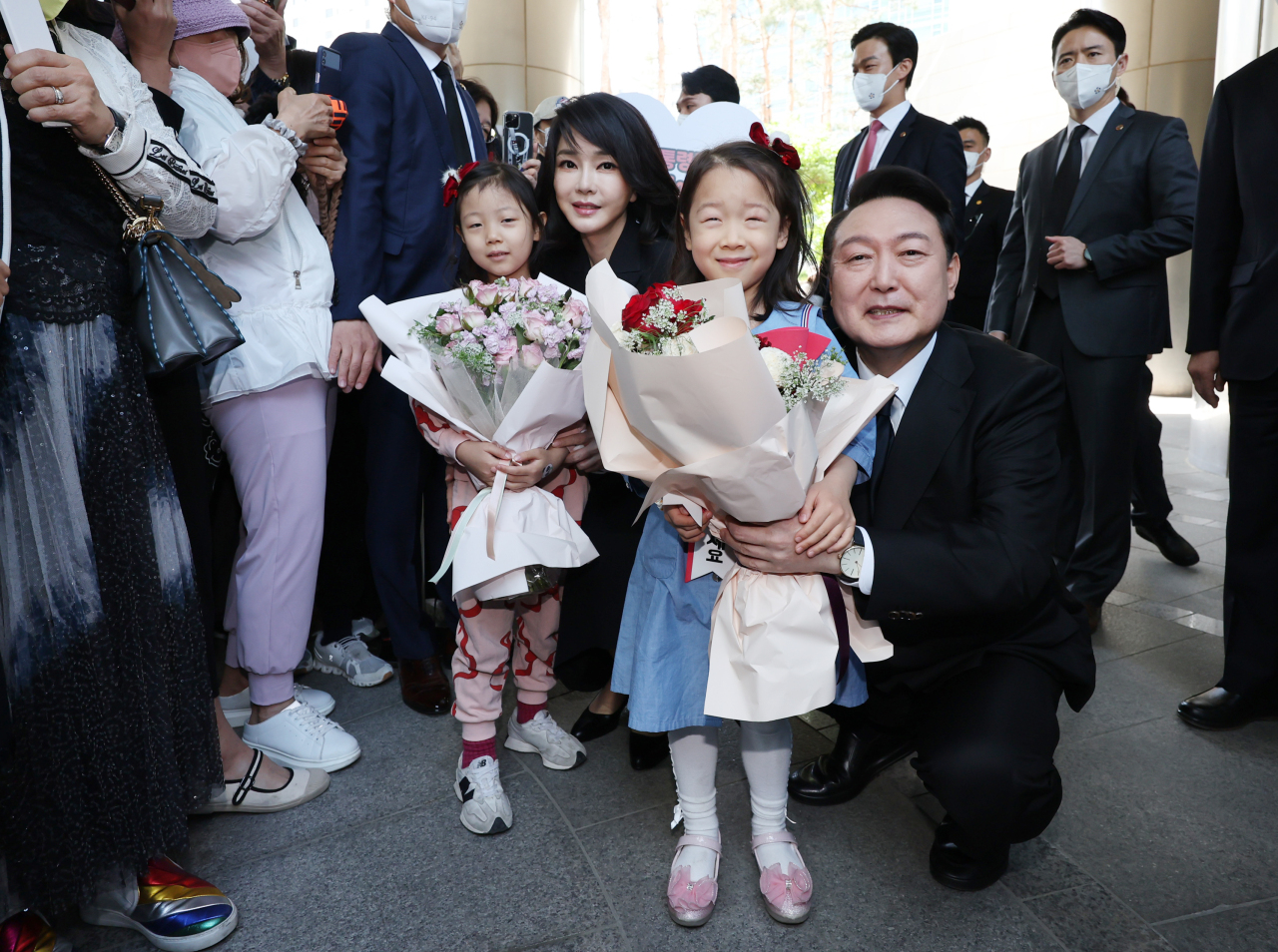 President Yoon Suk-yeol and first lady Kim Keon-hee receive bouquets from children as they leave their private home in southern Seoul on Tuesday morning for the inauguration ceremony. (Yonhap)