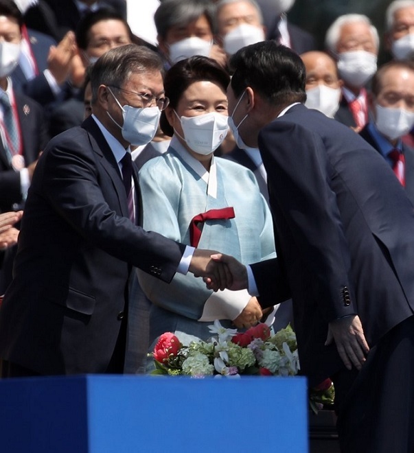 President Yoon Suk-yeol (right) shakes hands with former President Moon Jae-in prior to the inauguration ceremony at the National Assembly in Seoul on Tuesday. (Yonhap)