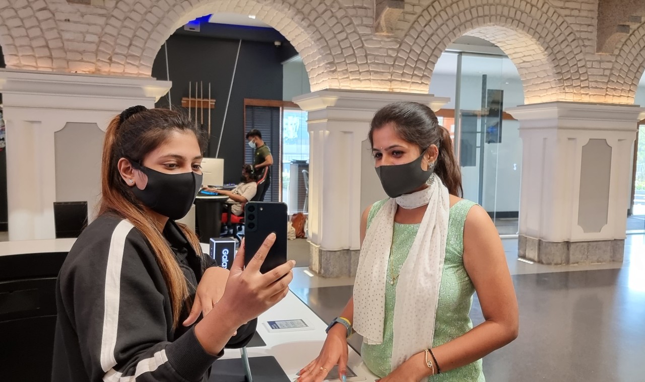 A visitor at Samsung Opera House, an electronic outlet in Bengaluru, India, is seen testing a Galaxy S22 phone with a clerk. (Samsung Electronics)