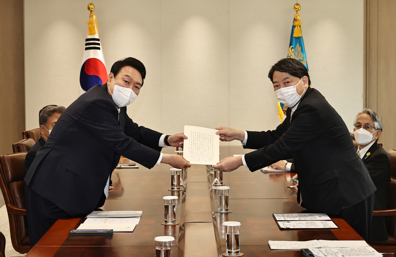 South Korean President Yoon Suk-yeol receives Japanese Prime Minister Fumio Kishida's personal letter, delivered from the Japanese Foreign Minister Yoshimasa Hayashi at the new presidential office in Yongsan-gu, Seoul, Tuesday. (Yonhap)