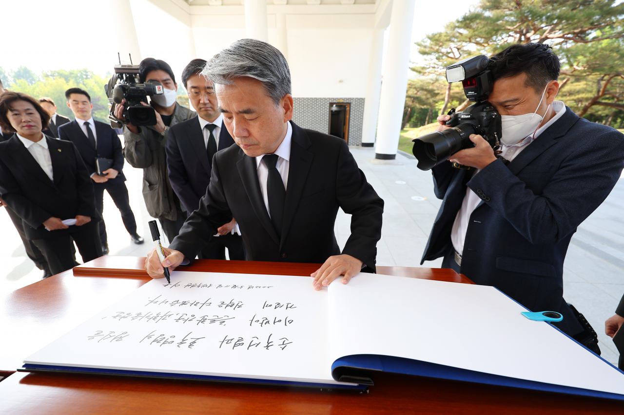 Defense Minister Lee Jong-sup writes a message on the visitors' book during a visit to the Seoul National Cemetery in central Seoul on Wednesday. (Yonhap)