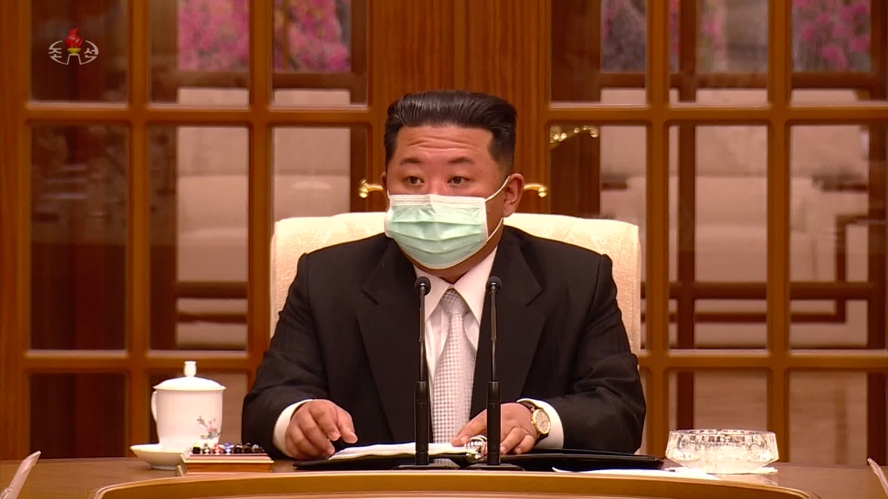 This photo, captured from North Korea’s Korean Central TV, shows leader Kim Jong-un wearing a face mask as he presides over a politburo meeting of the ruling Workers’ Party over the North’s first known case of COVID-19 in Pyongyang on Thursday. (Yonhap)