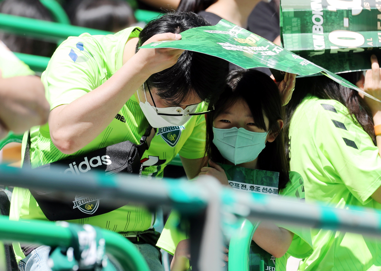A father and his daughter attend a K League professional football game between Jeonbuk Hyundai Motors and FC Seoul held in Jeonju, North Jeolla Province, May 5.