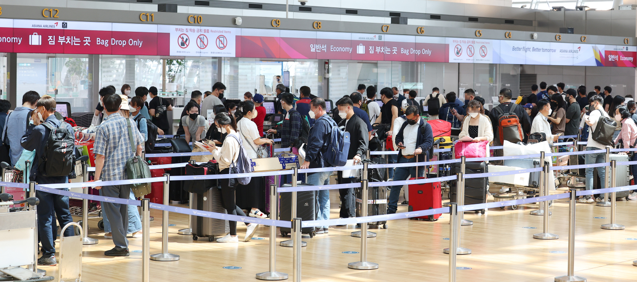 Passengers line up for boarding at Incheon International Airport on Saturday. (Yonhap)