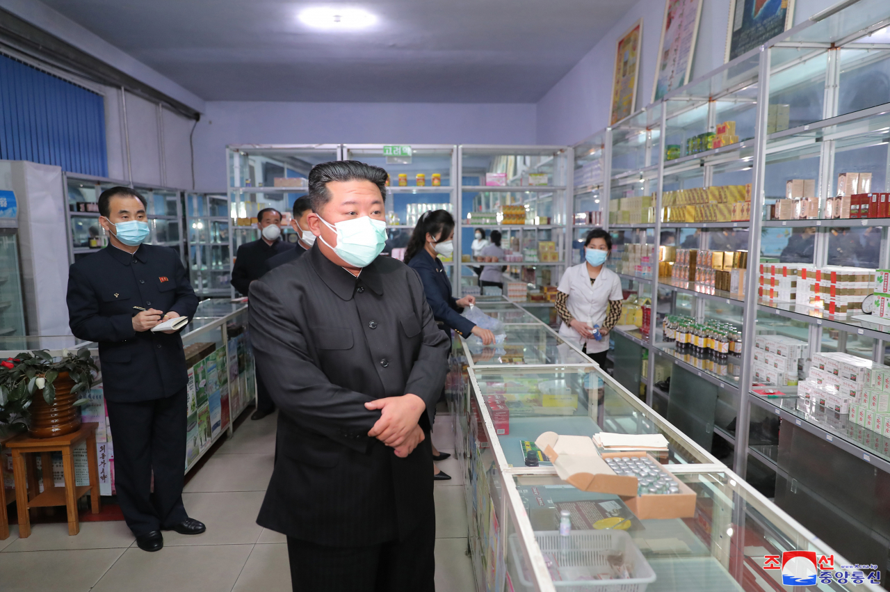 North Korean leader Kim Jong-un (front), wearing a face mask amid the COVID-19 outbreak, inspects a pharmacy in Pyongyang, in this undated photo released by the North's official Korean Central News Agency. Kim held an emergency consultative meeting of the political bureau of the Workers' Party at the headquarters of the party's Central Committee in Pyongyang on Sunday. In the meeting, Kim rebuked officials for failing to deliver medicine to its people in time and ordered the mobilization of soldiers to stabilize the supply of medicine in the capital. (KCNA)