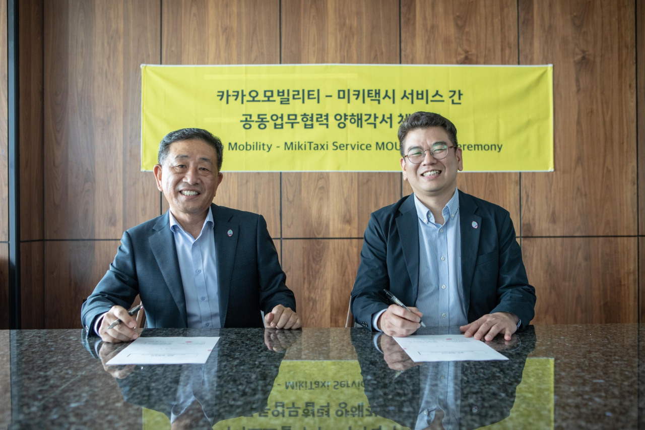Kakao Mobility Chief Business Officer Ahn Kyu-jin (right) and Miki Taxi President Im Hong-soon sign memorandum of understanding to offer Kakao’s mobility services in Guam (Kakao Mobility)