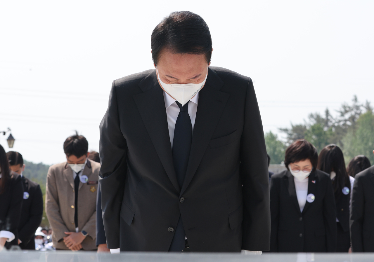 President Yoon Suk-yeol pays a silent tribute after offering flowers and incense at the National Cemetery in Buk-gu, Gwangju, Wednesday, the 42nd anniversary of the May 18 Gwangju Democratization Movement.(Yonhap)