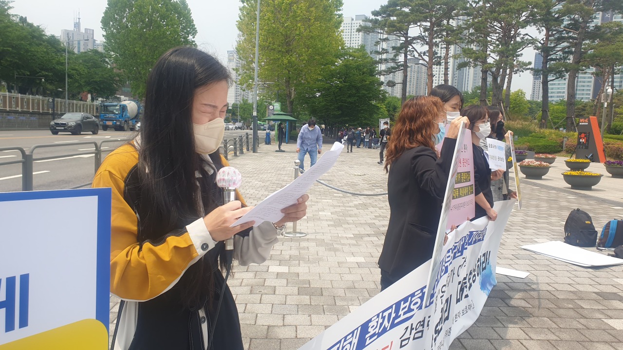 Families of COVID-19 victims speak outside the presidential office in Yongsan, central Seoul, on Wednesday.