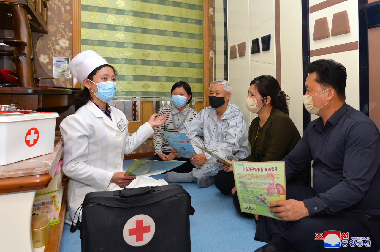 This photo released by the North's Korean Central News Agency on Tuesday, shows a medical worker instructing people on personal hygiene practices in Pyongyang. (KCNA)