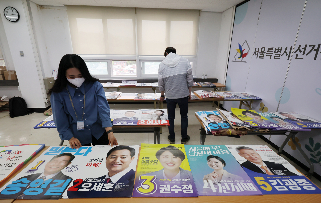 Election officials check posters of candidates running in the June 1 local elections at an election management committee office in Seoul on Wednesday. (Yonhap)