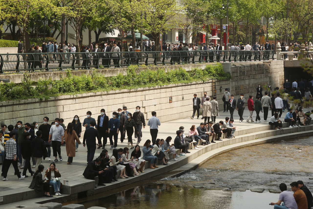 People walk along Cheonggye Stream during lunchtime in central Seoul on April 20. (Yonhap)