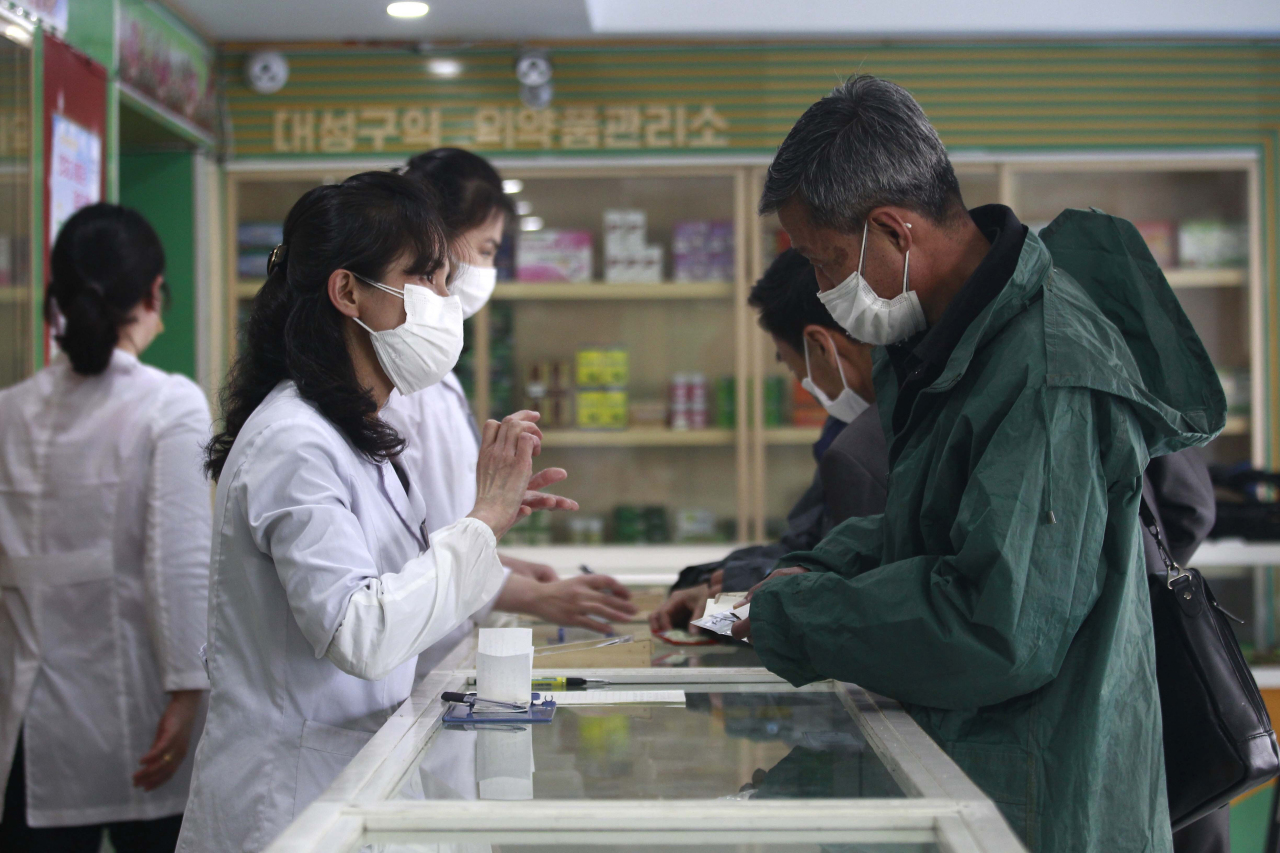 화요일 조선중앙통신이 공개한 이 사진에는 약국에서 일하는 의료진이 두 겹의 마스크를 쓰고 있는 모습이 보인다.  (연합)