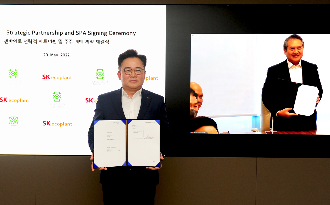 SK ecoplant 首席执行官 Park Kyung-il（左）和国库控股董事总经理 Amirul Feisal Wan Zahir 周五在网上开会签署股份购买协议后合影留念。  （SK生态植物）