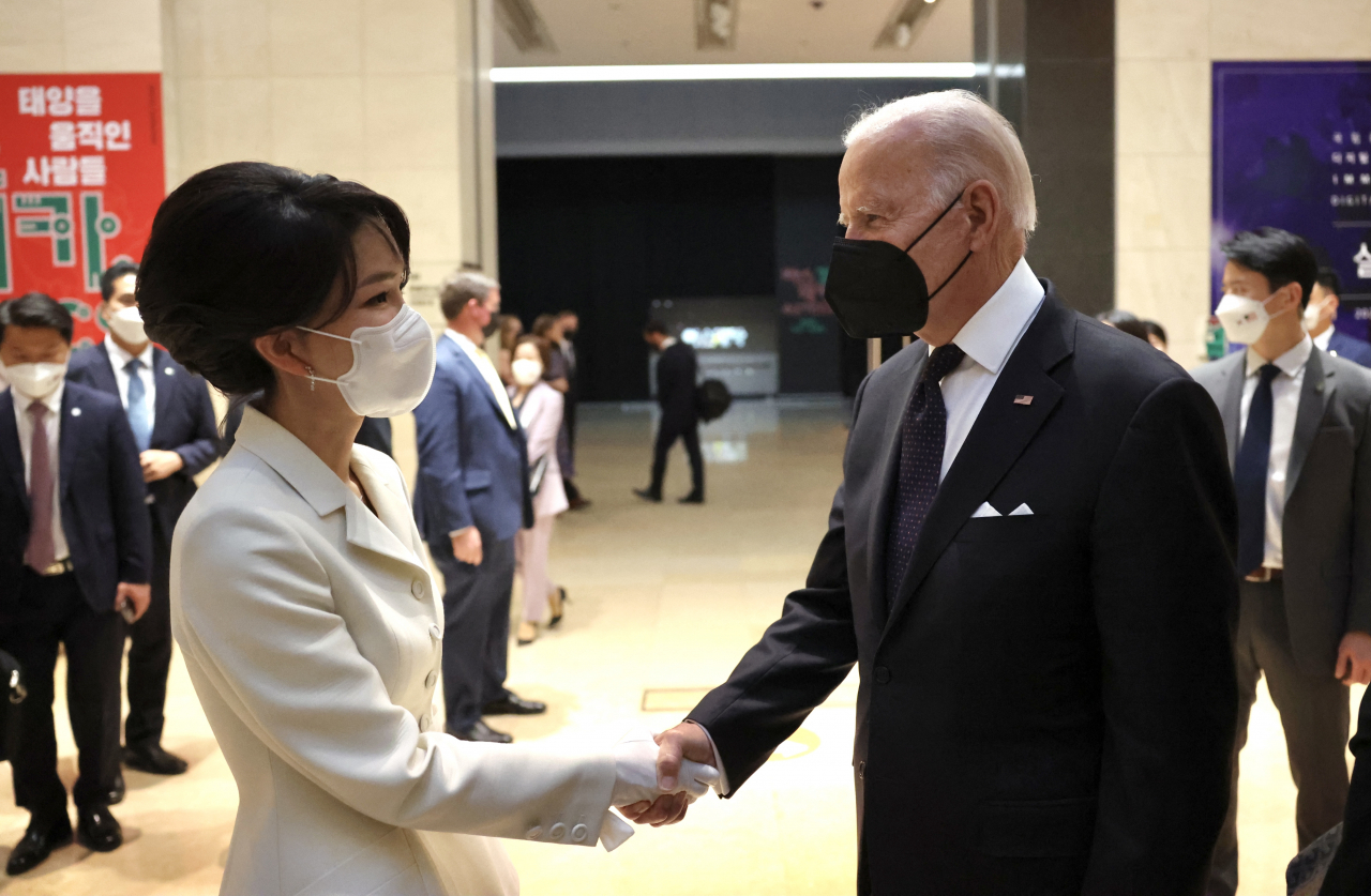 This photo, provided by the presidential office, shows first lady Kim Keon-hee (L) and US President Joe Biden shaking hands ahead of a state dinner at the National Museum of Korea in Seoul last Saturday. (Presidential office)