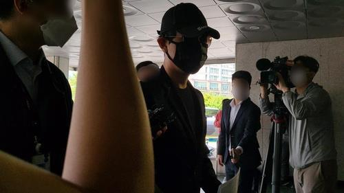 A crypto investor (C), accused of ringing the doorbell of the apartment of Do Kwon, co-founder and CEO of Terraform Labs, enters Seongdong Police Station in Seoul last Monday. (Yonhap)