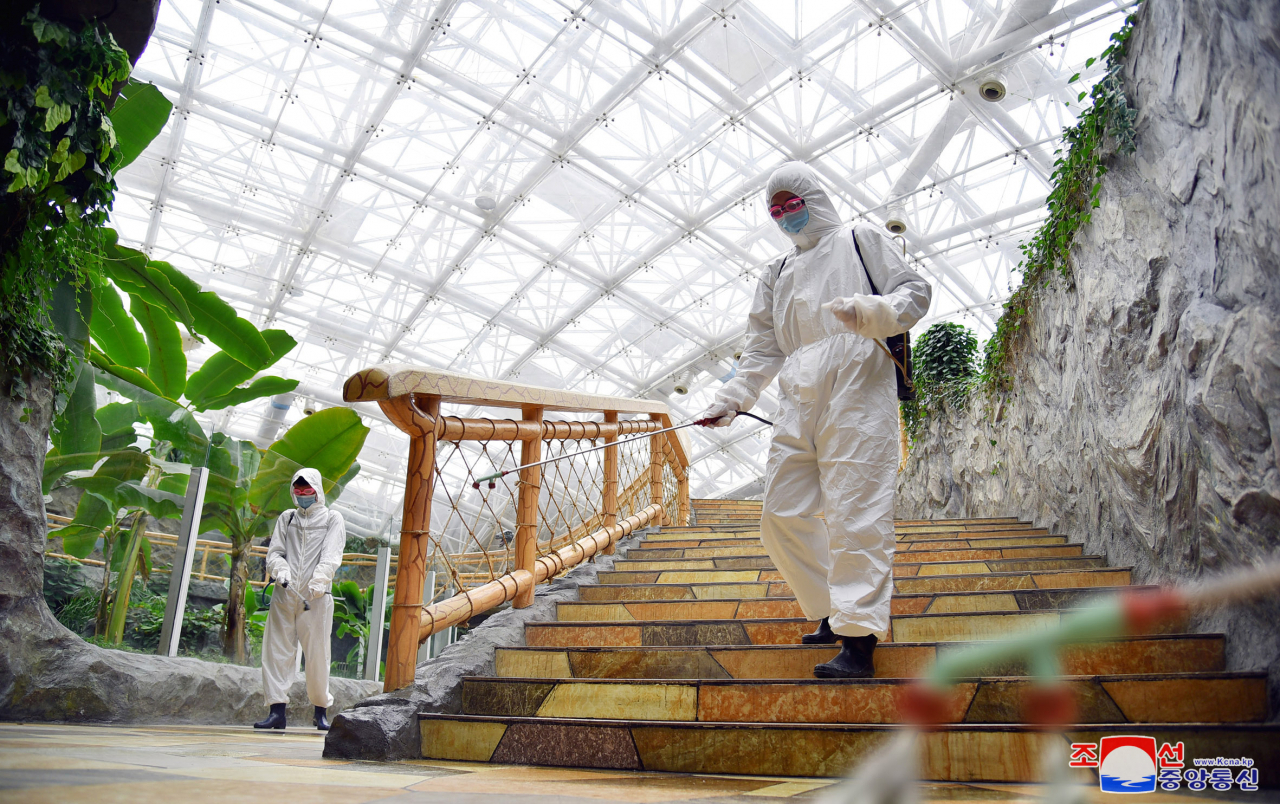 In this undated file photo released by the North's official Korean Central News Agency on Sunday, North Korean health care workers carry out disinfection work at the Pyongyang Central Zoo. (KCNA)