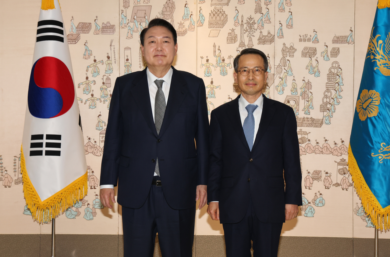 President Yoon Suk-yeol (L) poses with National Intelligence Service Director Kim Kyou-hyun after presenting him with a letter of appointment at the presidential office in Seoul on Friday. (Yonhap)