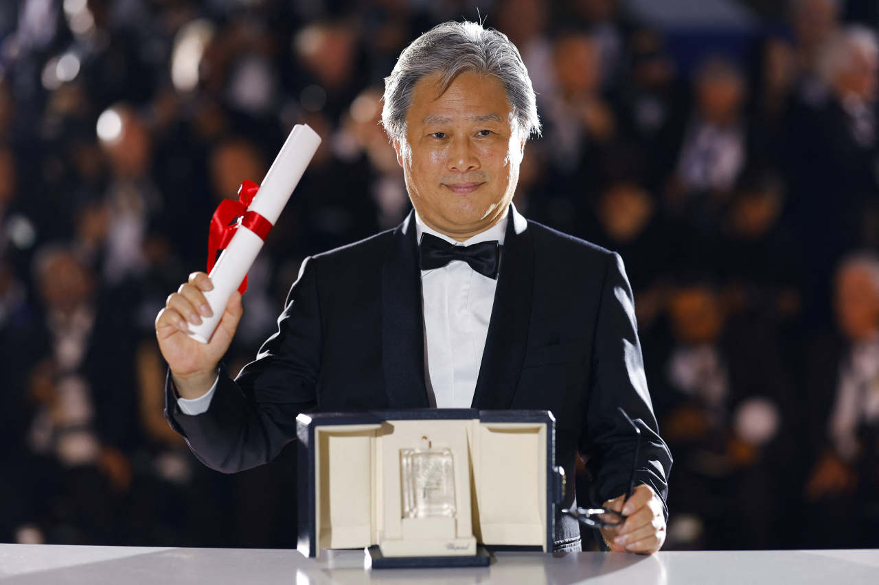 South Korean director Park Chan-wook of “Decision to Leave” poses for photos after winning the best director award at the 75th Cannes Film Festival in Cannes, France, on Saturday. (Reuters-Yonhap)