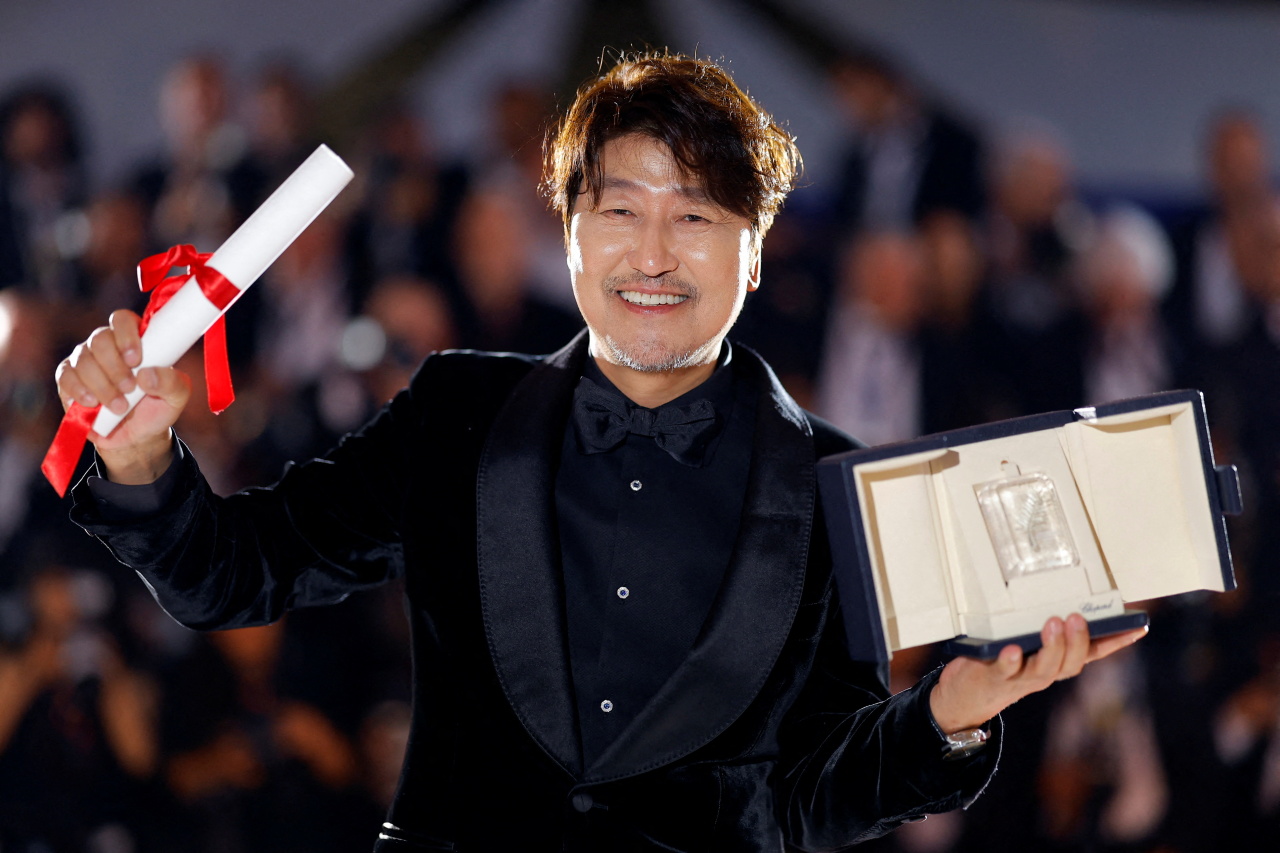 South Korean actor Song Kang-ho of “Broker” poses for photos after winning the award for best actor at the 75th Cannes Film Festival in southern France, Saturday. (Reuters-Yonhap)