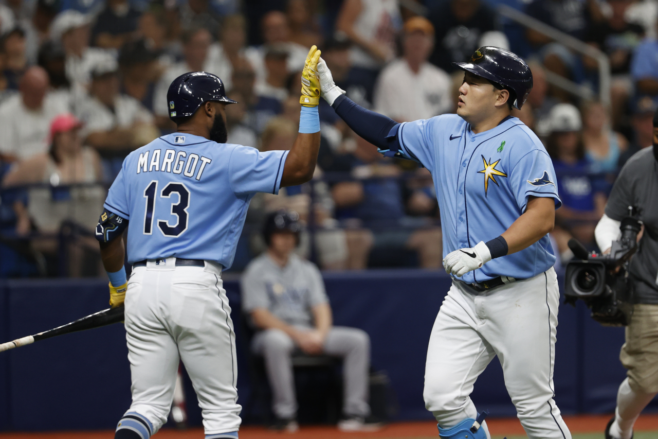 In this Associated Press photo, Choi Ji-man of the Tampa Bay Rays (R) celebrates with teammate Manuel Margot after hitting a solo home run against the New York Yankees during the bottom of the second inning of a Major League Baseball regular season game at Tropicana Field in St. Petersburg, Florida, on Sunday. (AP)