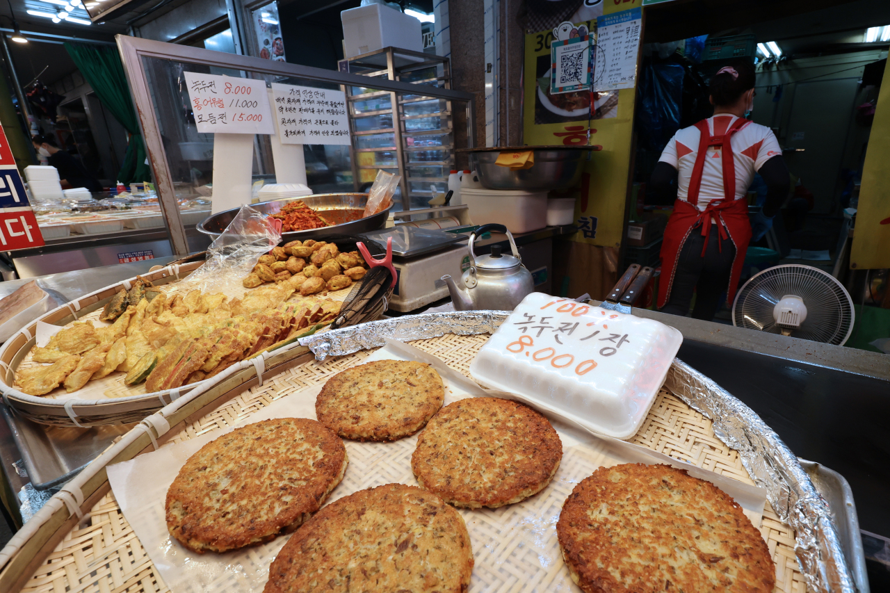 A posting at a market in Seoul on Thursday informs customers of an “inevitable” hike in prices of some Korean traditional pancakes -- after freezing in price tags for five years -- amid high import prices of ingredients for food. (Yonhap)