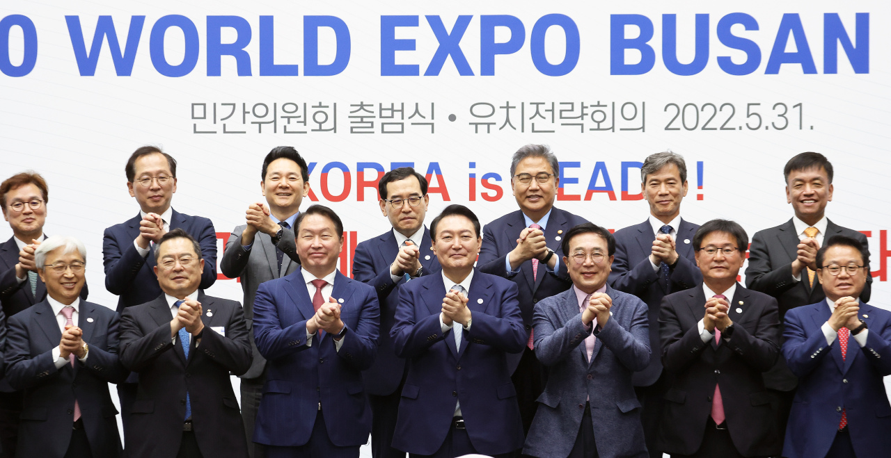President Yoon Suk-yeol (center), Korea Chamber of Commerce and Industry Chairman Chey Tae-won (third from left) and other business and political leaders pose to celebrate the launch of a civilian committee supporting Busan’s bid for 2030 World Expo on Tuesday. (Yonhap)