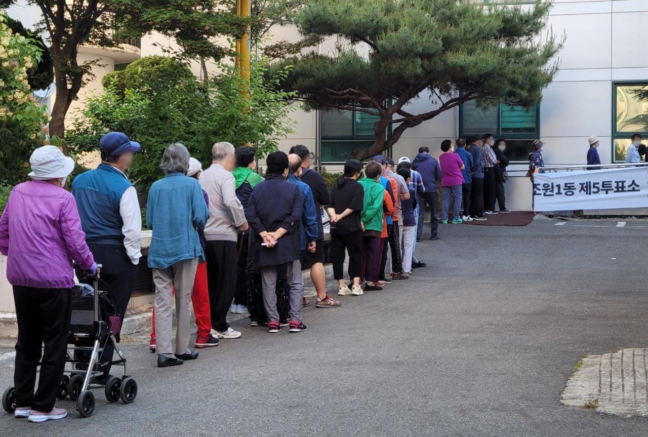 Voters line up outside a polling location in Suwon, Gyeonggi Province, on Wednesday morning. (Yonhap)