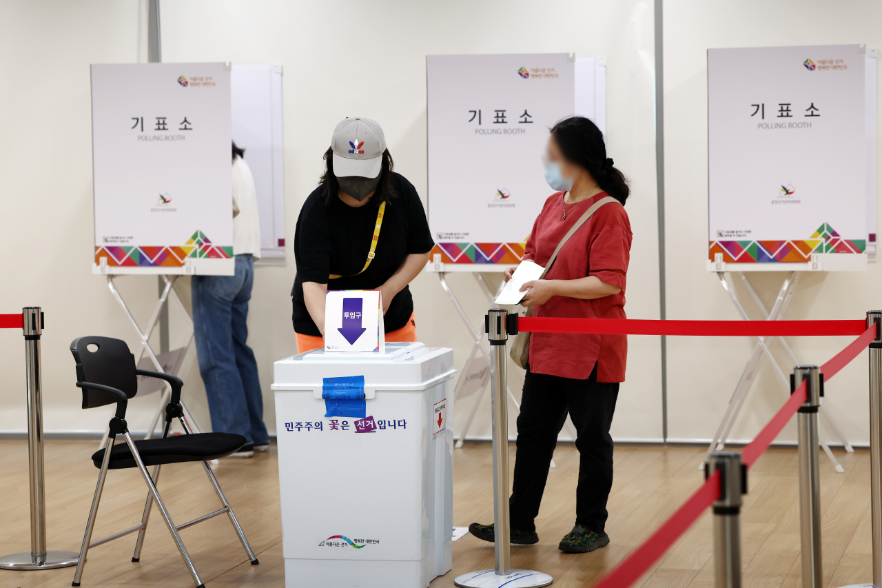 Voters cast their ballots at a polling booth in Oksu-dong, Seoul, Wednesday. (Yonhap)