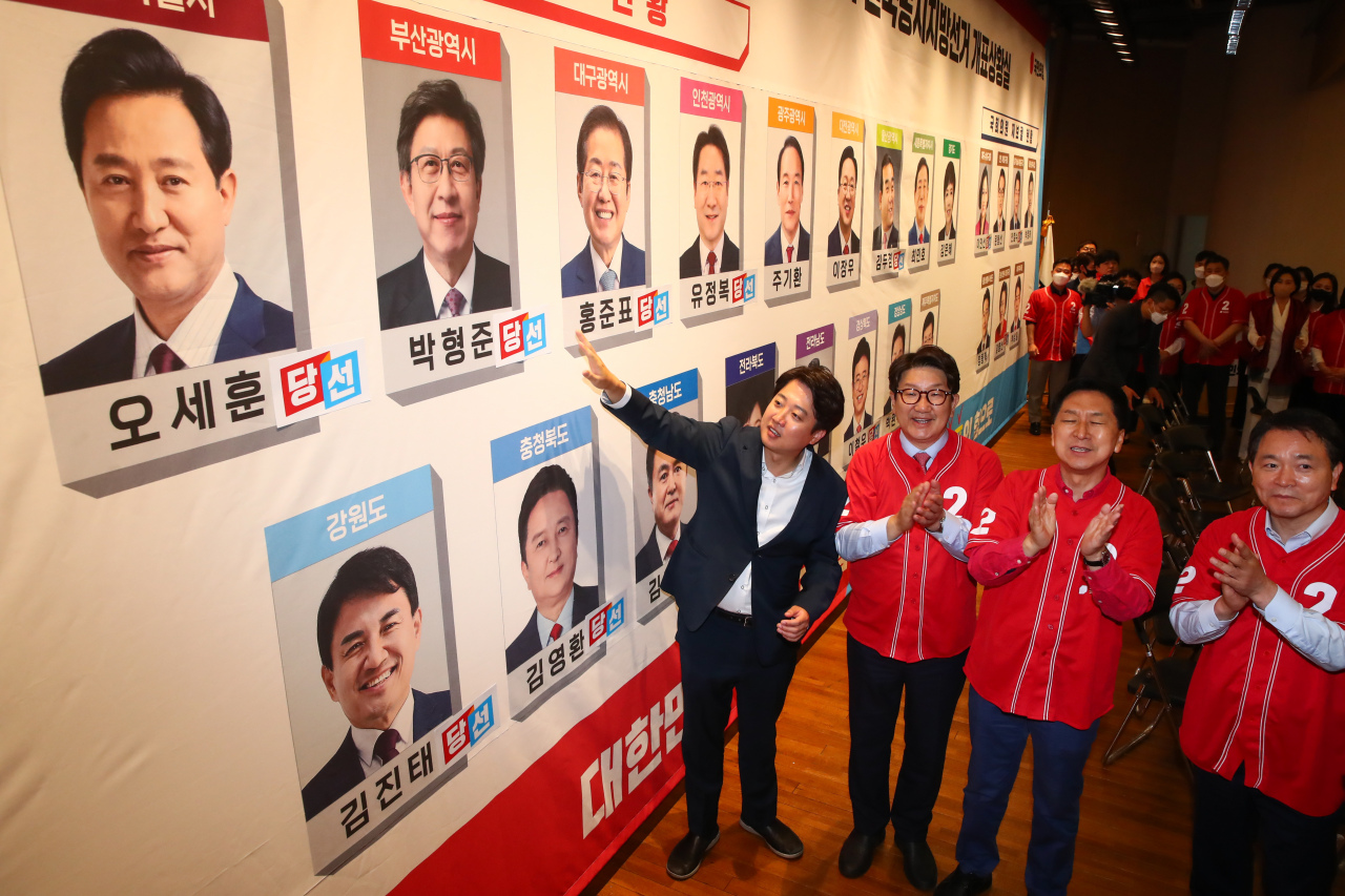 Officials with the ruling People Power Party post stickers printed with 