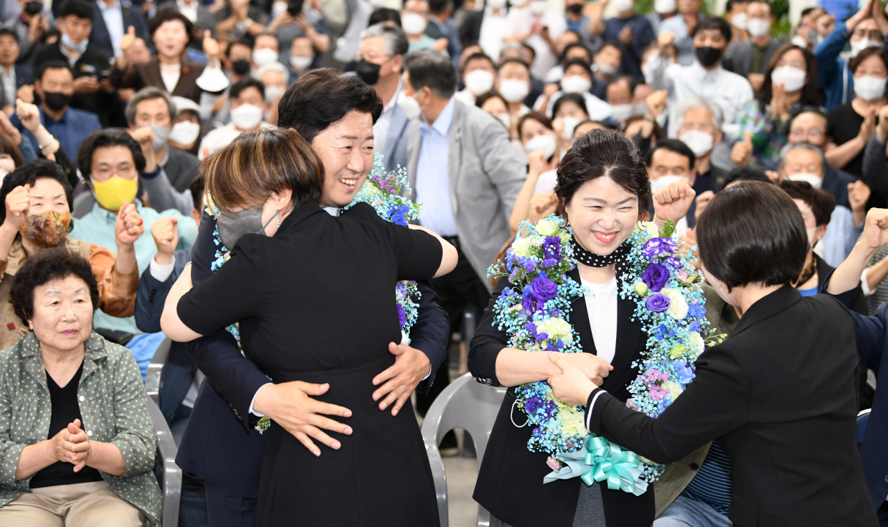 Jeju Governor-elect Oh Young-hun (left) and his wife Park Sun-hee are congratulated by his supporters at his campaign office in Jeju City, Jeju Island, after exit polls project him to be the winner the election on Wednesday. (Yonhap)