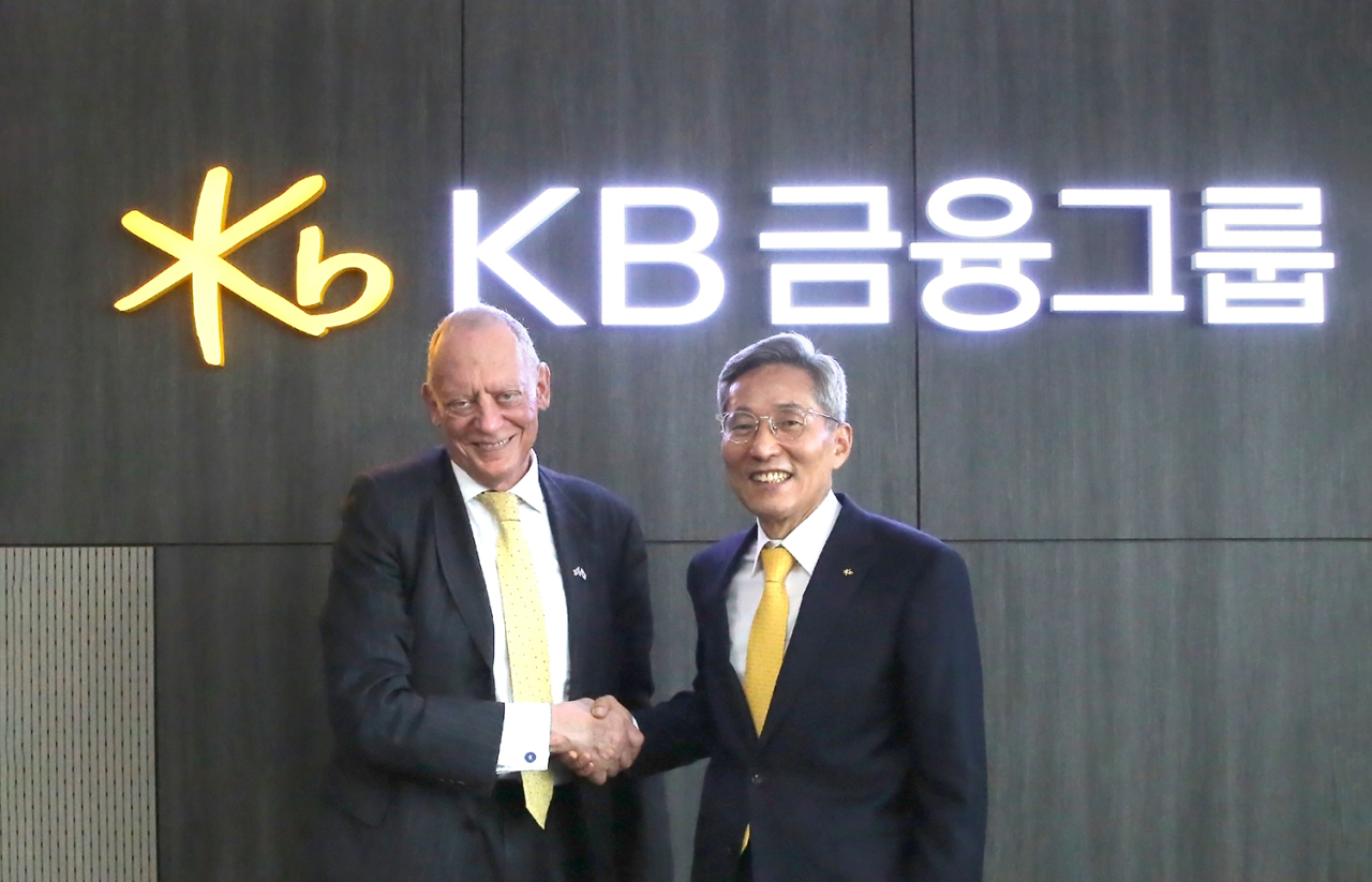 cap/ KB Financial Group Chairman Yoon Jong-kyoo shakes hands with the UK’s Department for Business, Energy & Industrial Strategy Deputy Minister Garry Grimstone at KB headquarters in western Seoul on Friday. (KB Financial Group)
