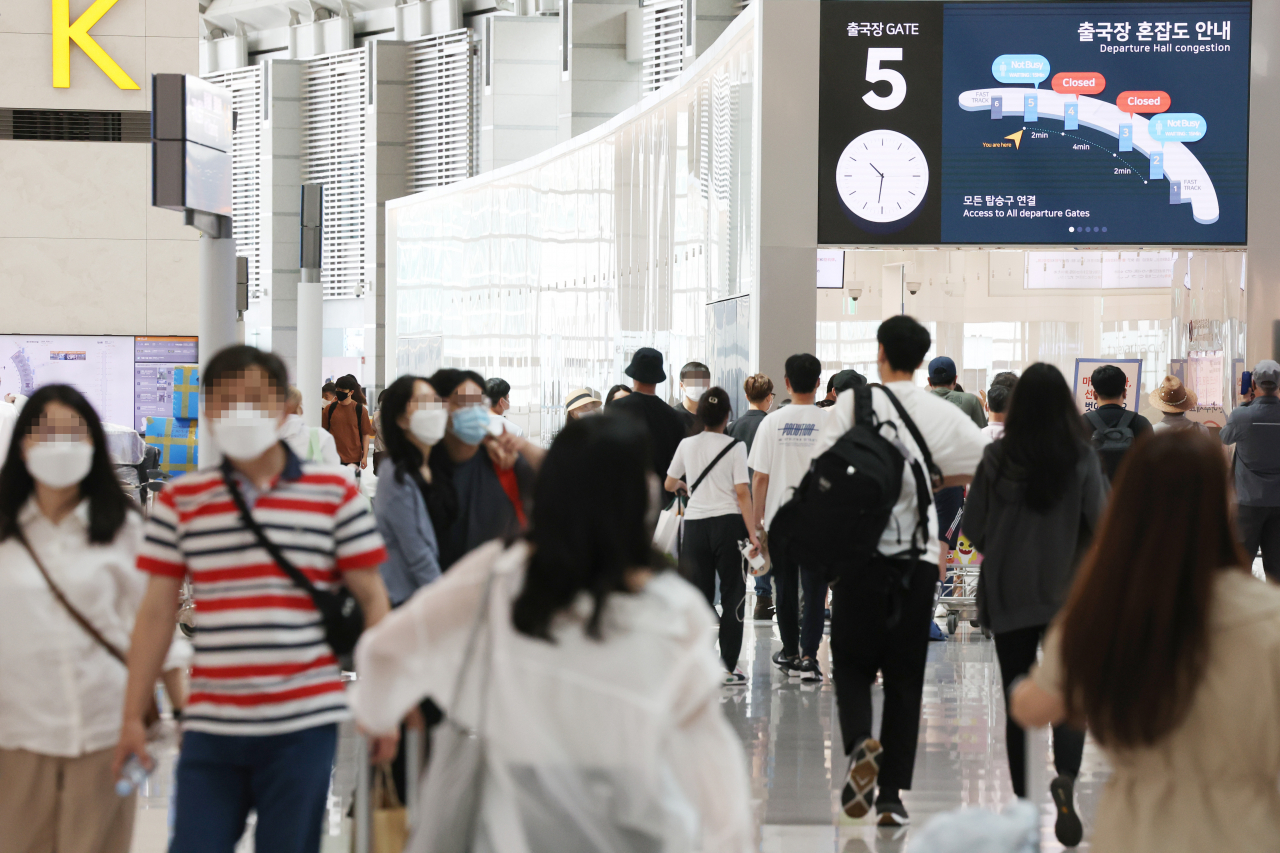 Travelers move about Incheon International Airport, west of Seoul, on Sunday. (Yonhap)