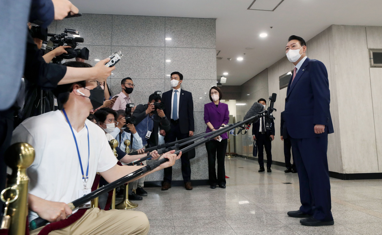 President Yoon Suk-yeol takes reporters' questions as he arrives at the presidential office in Seoul on Thursday. (Yonhap)