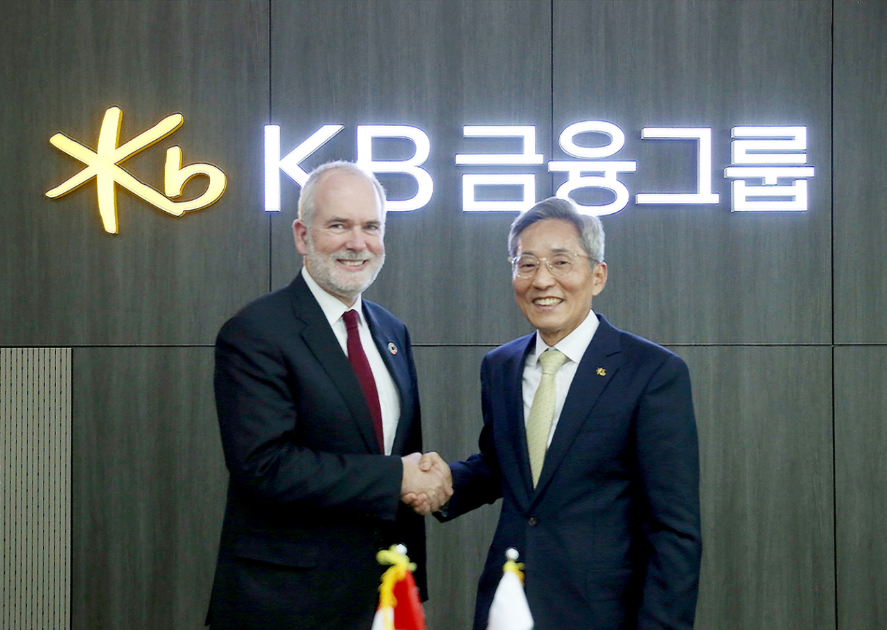KB Financial Group Chairman Yoon Jong-kyoo (right) and Tomas Anker Christensen, Denmark’s ambassador for climate change, pose for a picture at the KB headquarters in western Seoul on Thursday. (KB Financial Group)