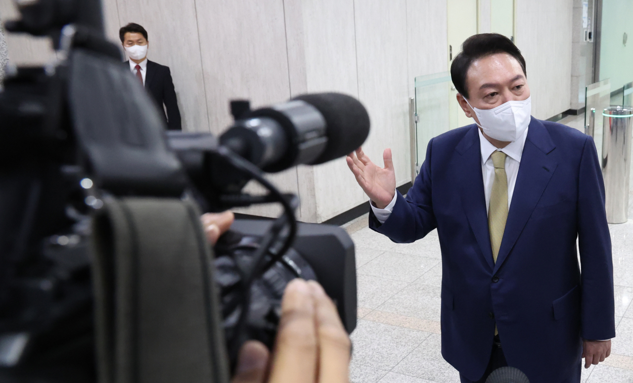 President Yoon Suk-yeol takes reporters' questions as he arrives at the presidential office in Seoul on Monday. (Yonhap)