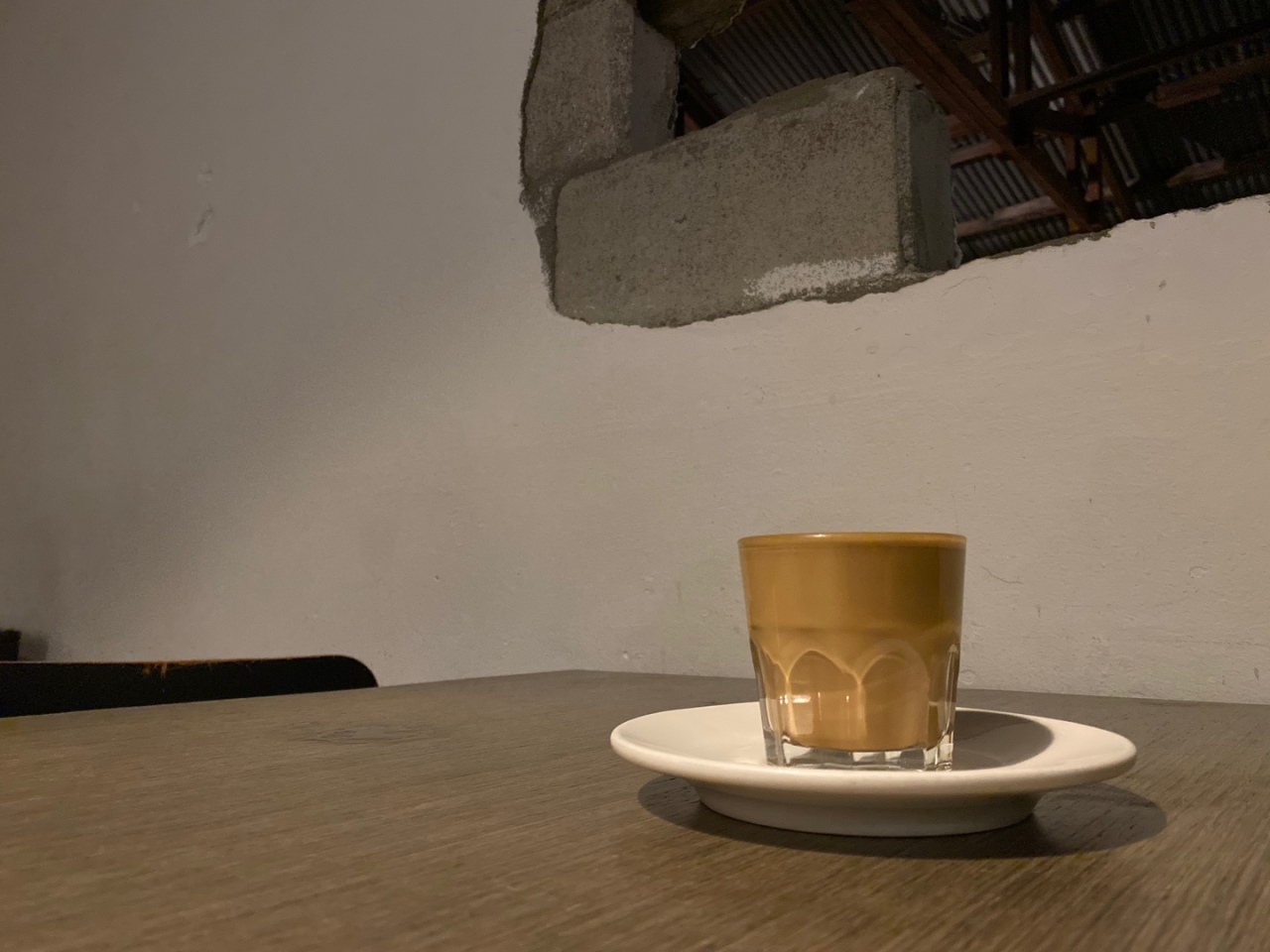 A glass of a coffee drink is photographed in an industrial-style cafe in Seoul. (Yim Hyun-su/The Korea Herald)