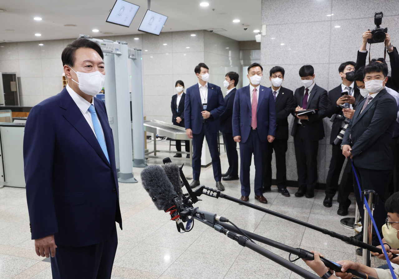 President Yoon Suk-yeol takes reporters' questions as he arrives at the presidential office in Seoul on Tuesday. (Yonhap)